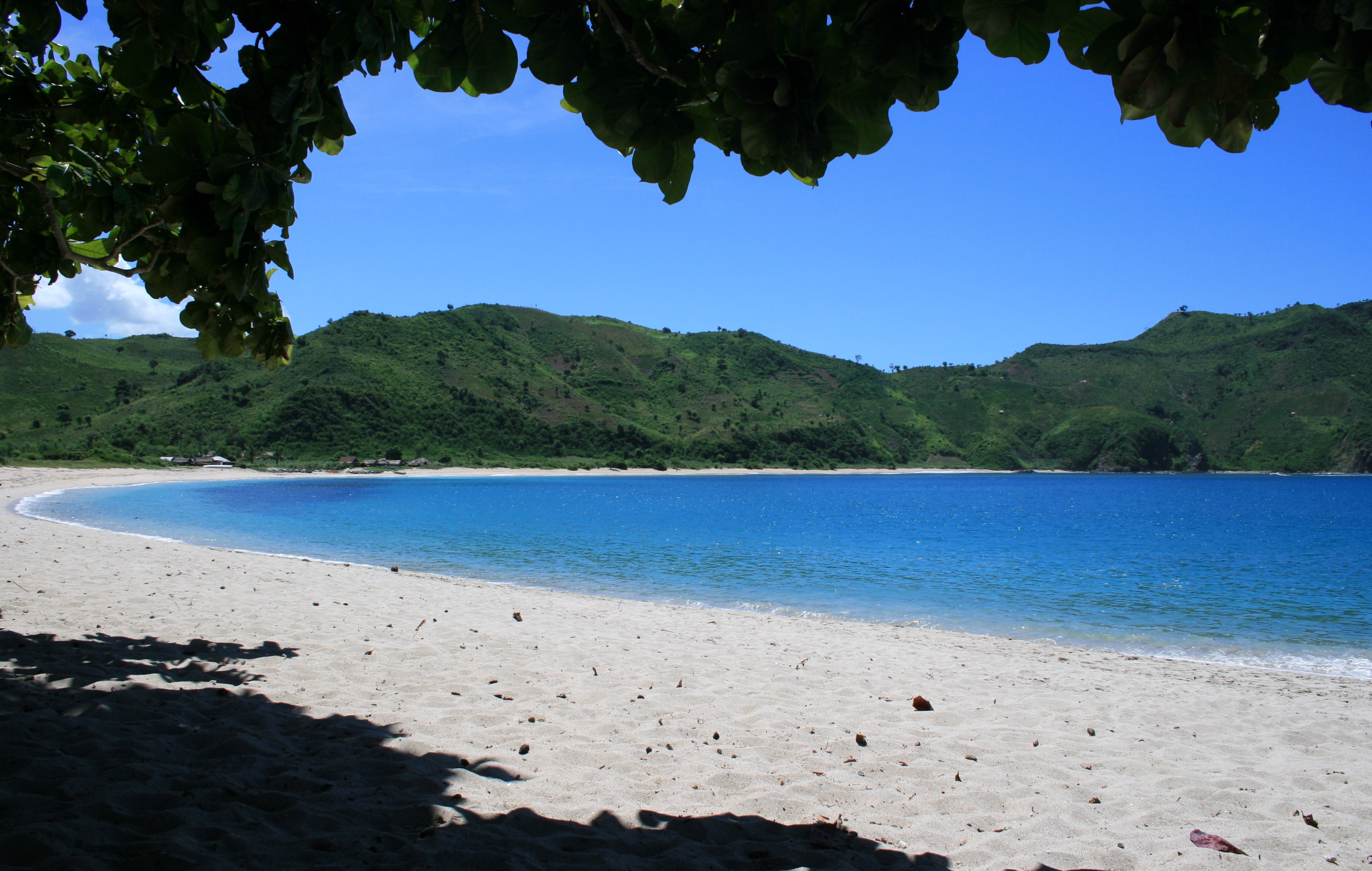Mawun Beach near Kuta Lombok — a crescent of pale sand framed by green headlands on the south coast