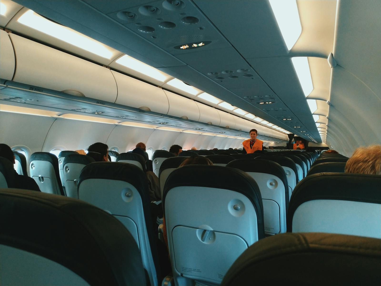 Interior of an aircraft cabin with seated passengers