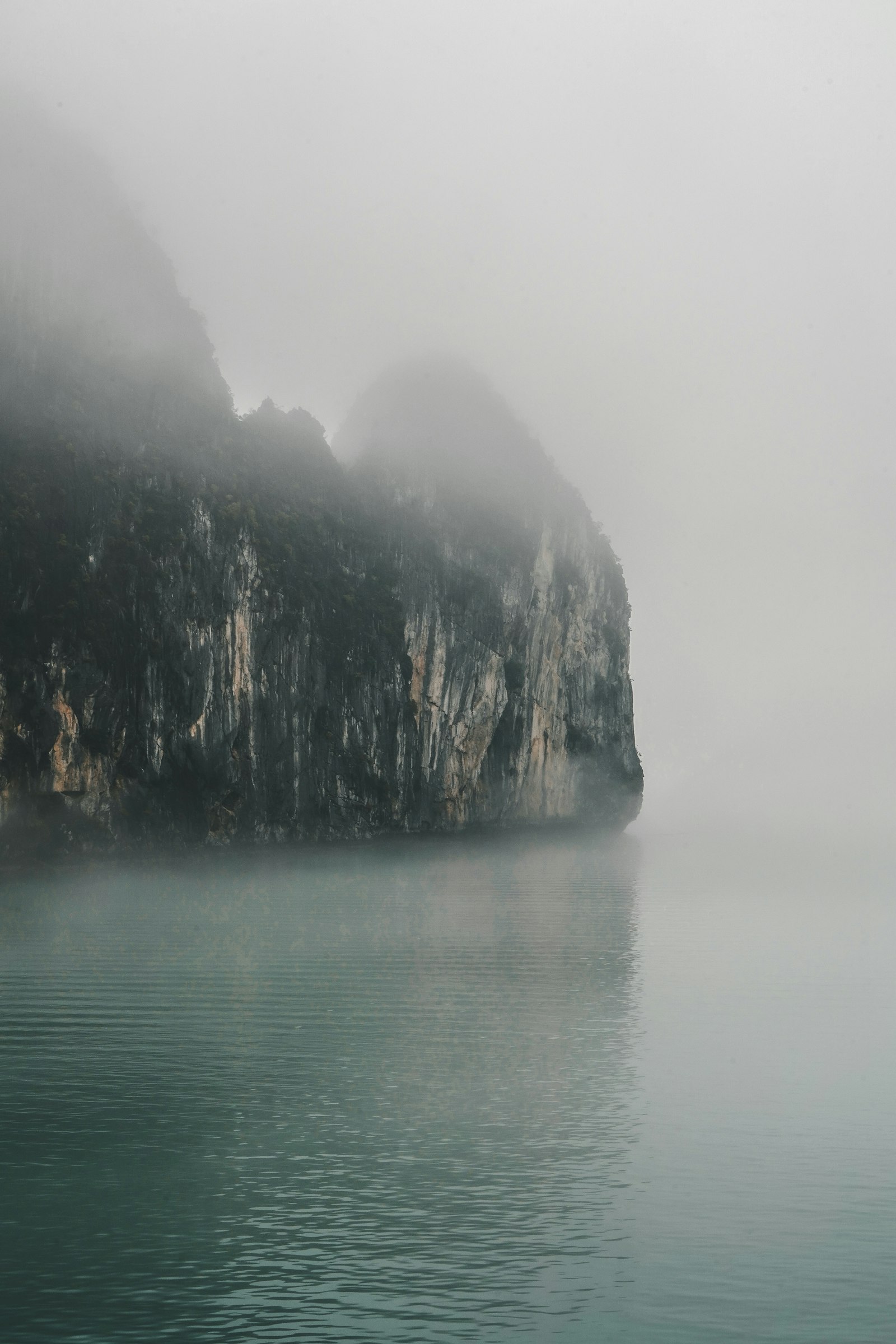 Fog blanketing limestone karsts in Halong Bay Vietnam