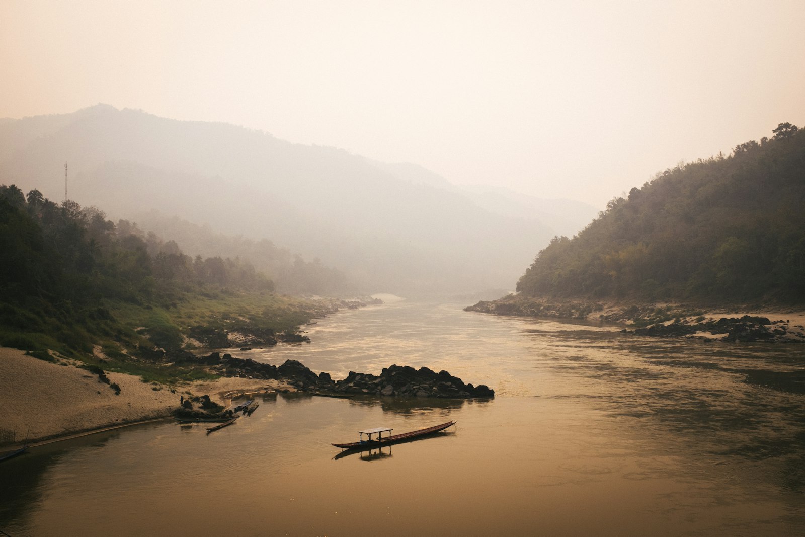 Wooden longtail on the Mekong at dusk