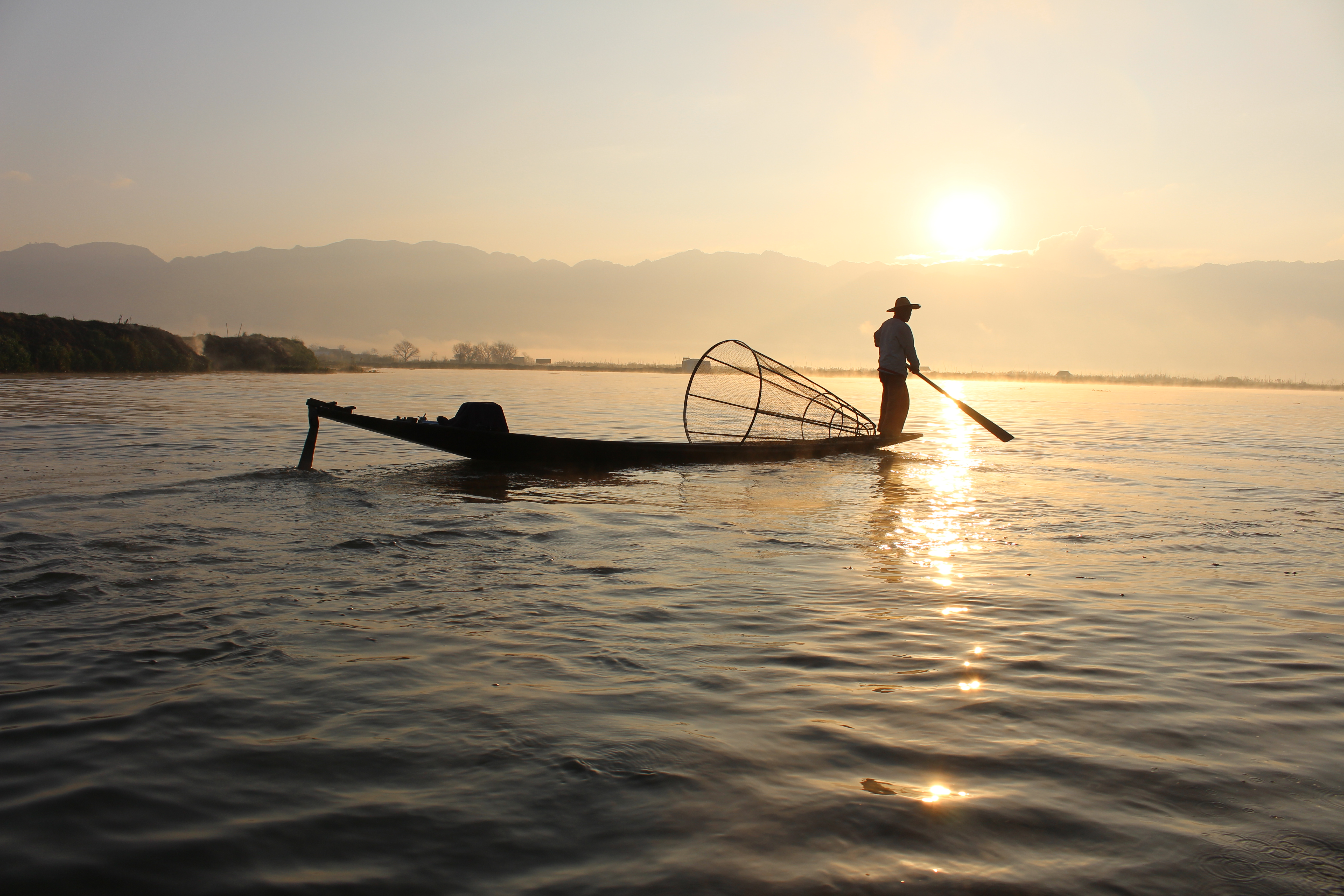 Intha leg-rowing fisherman at dawn on Inle Lake