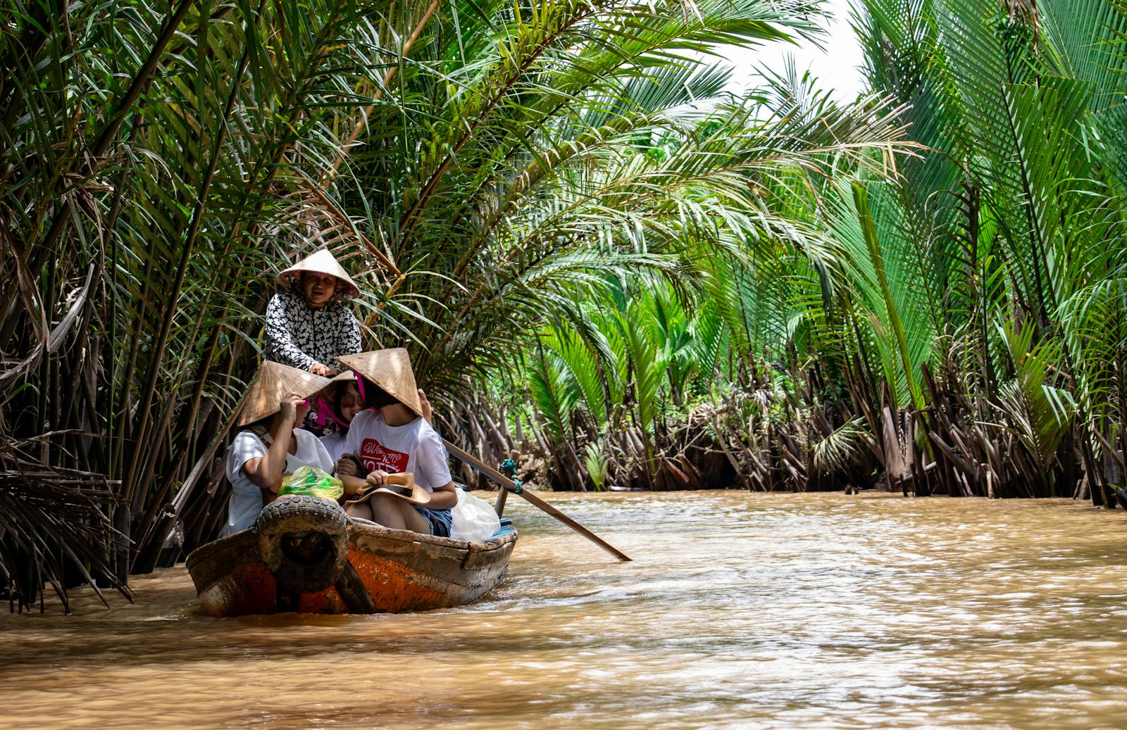 Women rowing a boat through the Mekong Delta