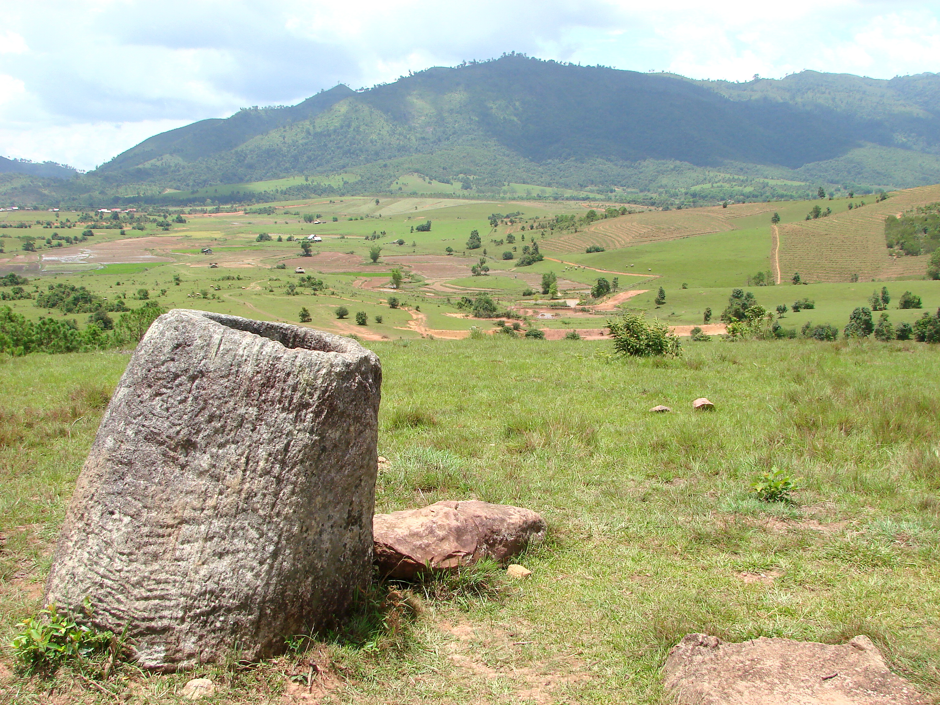 Wide view of megalithic stone jars scattered across grassland at the Plain of Jars, Phonsavan, Xieng Khouang Province, Laos