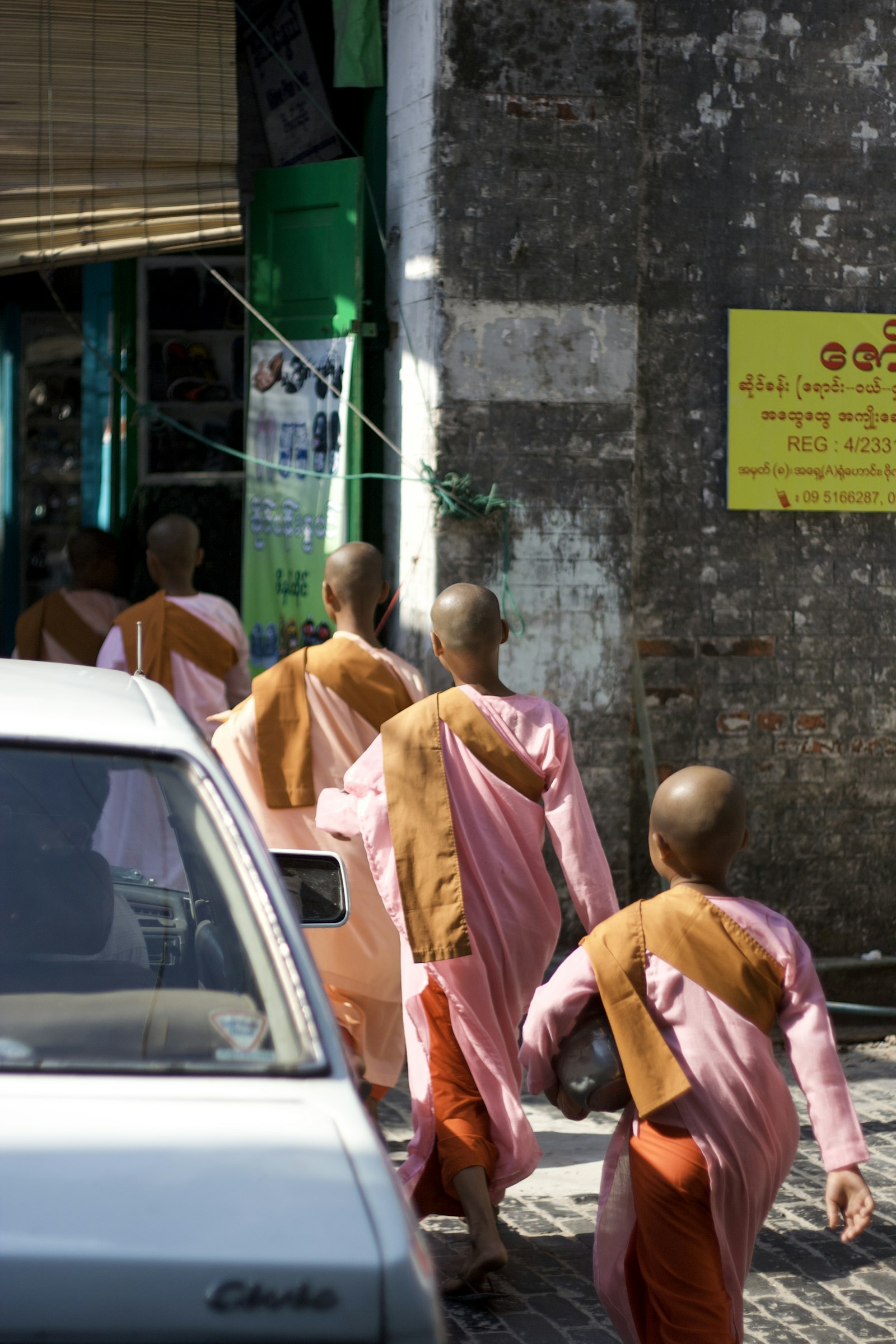 Group of monks walking down a Yangon street at dawn