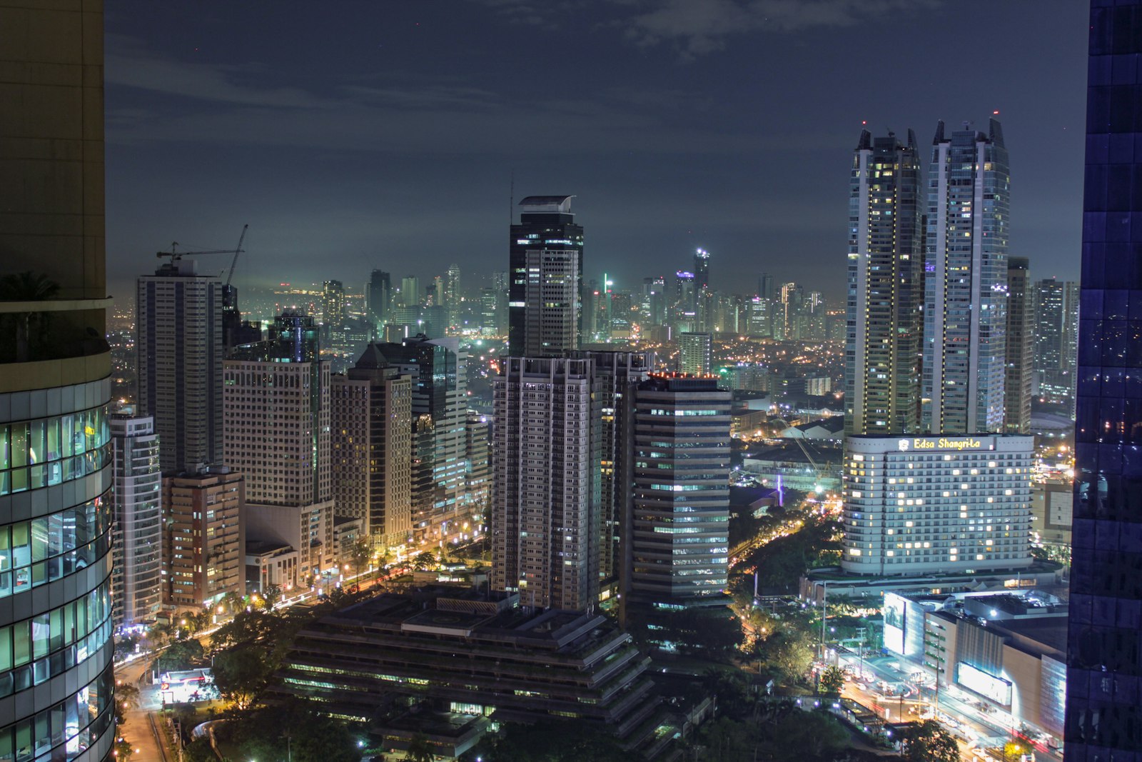 Manila city skyline at night with illuminated high-rise buildings