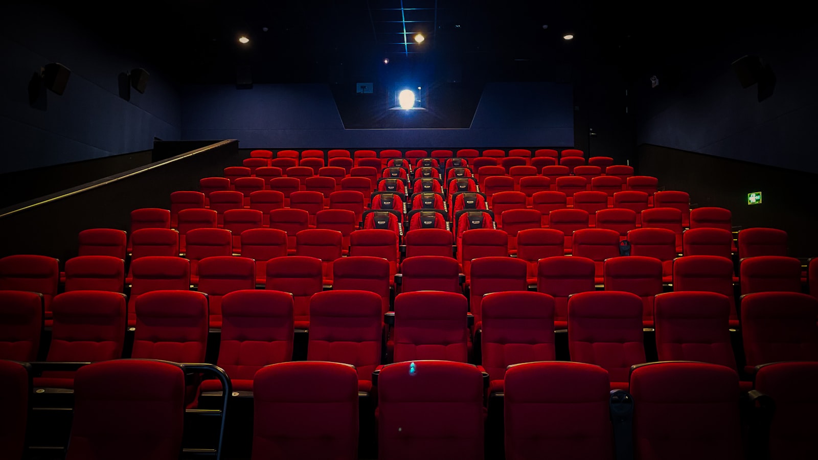 Empty cinema with red seats and screen