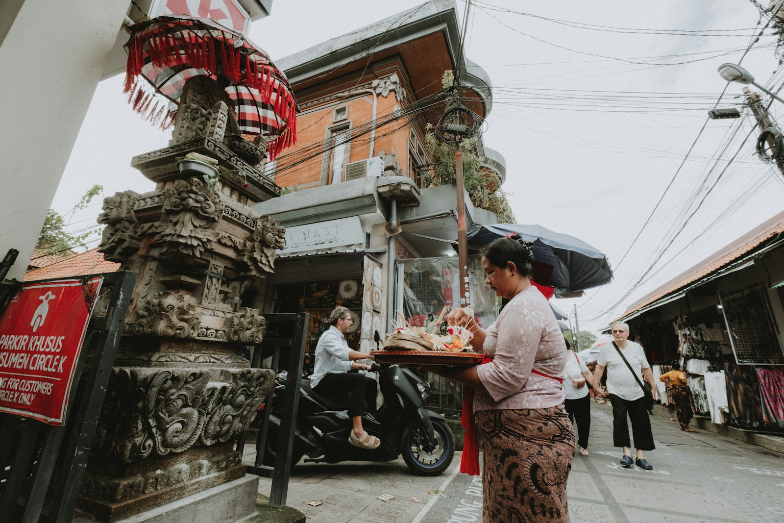 Balinese woman in temple dress carrying offerings