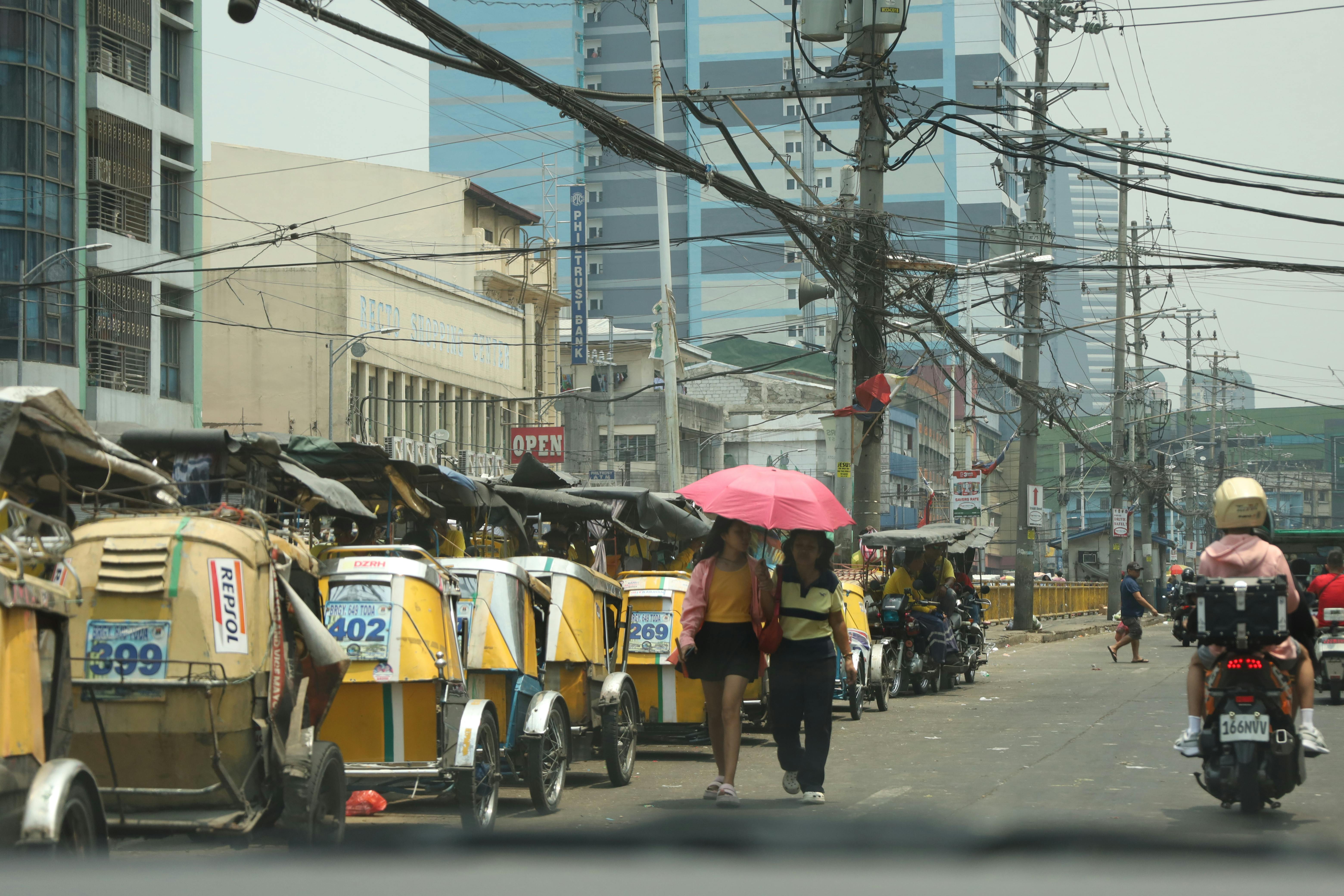 Manila street with tricycle taxis and pedestrians