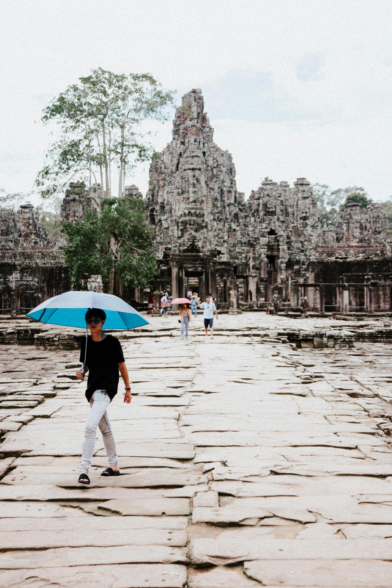 Visitors exploring the Bayon temple causeway in Cambodia
