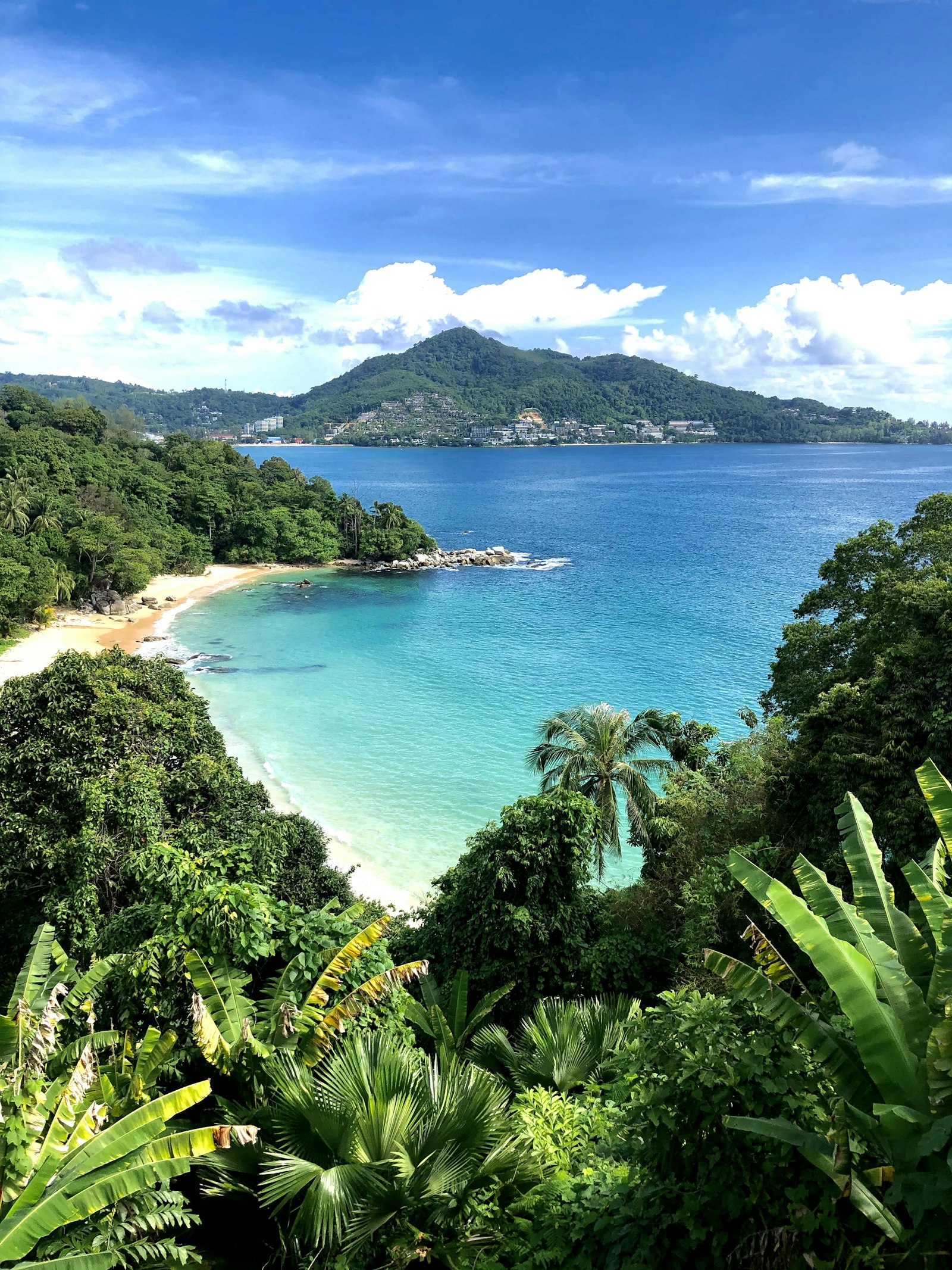 Tropical beach in Phuket, Thailand seen from an elevated viewpoint — turquoise water and palm-lined coast