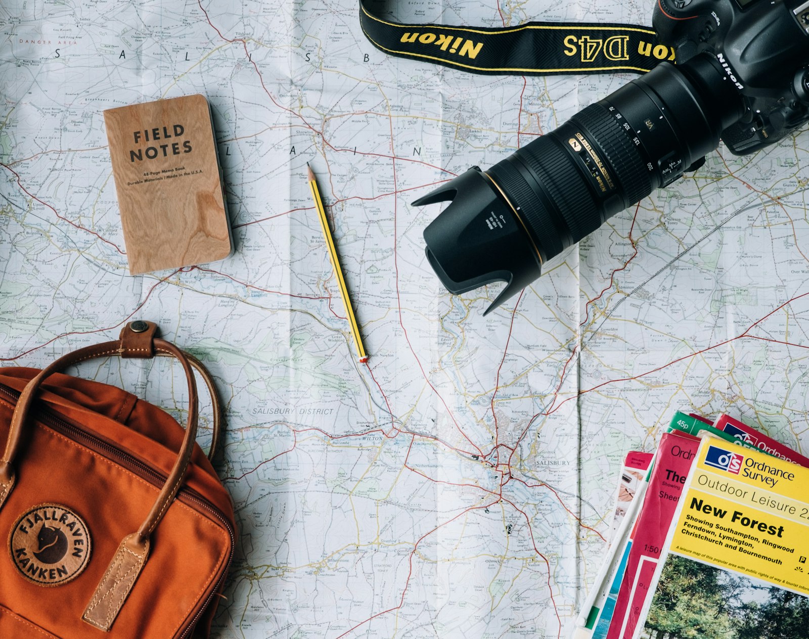 Travel flatlay with map, notebook, camera and backpack