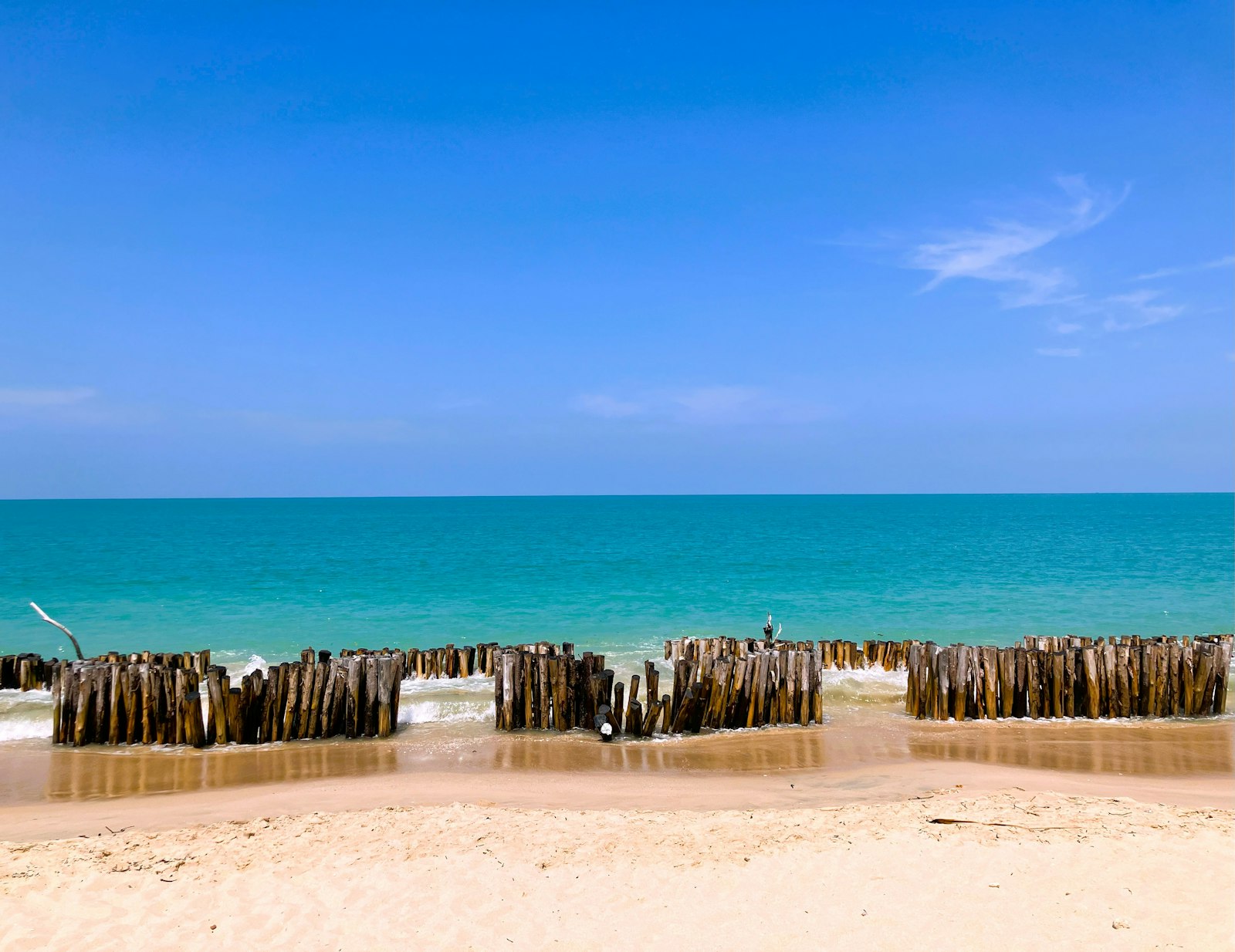 Khao Lak beach in Thailand — gently shelving sand, wooden beach structures, and Andaman Sea coast