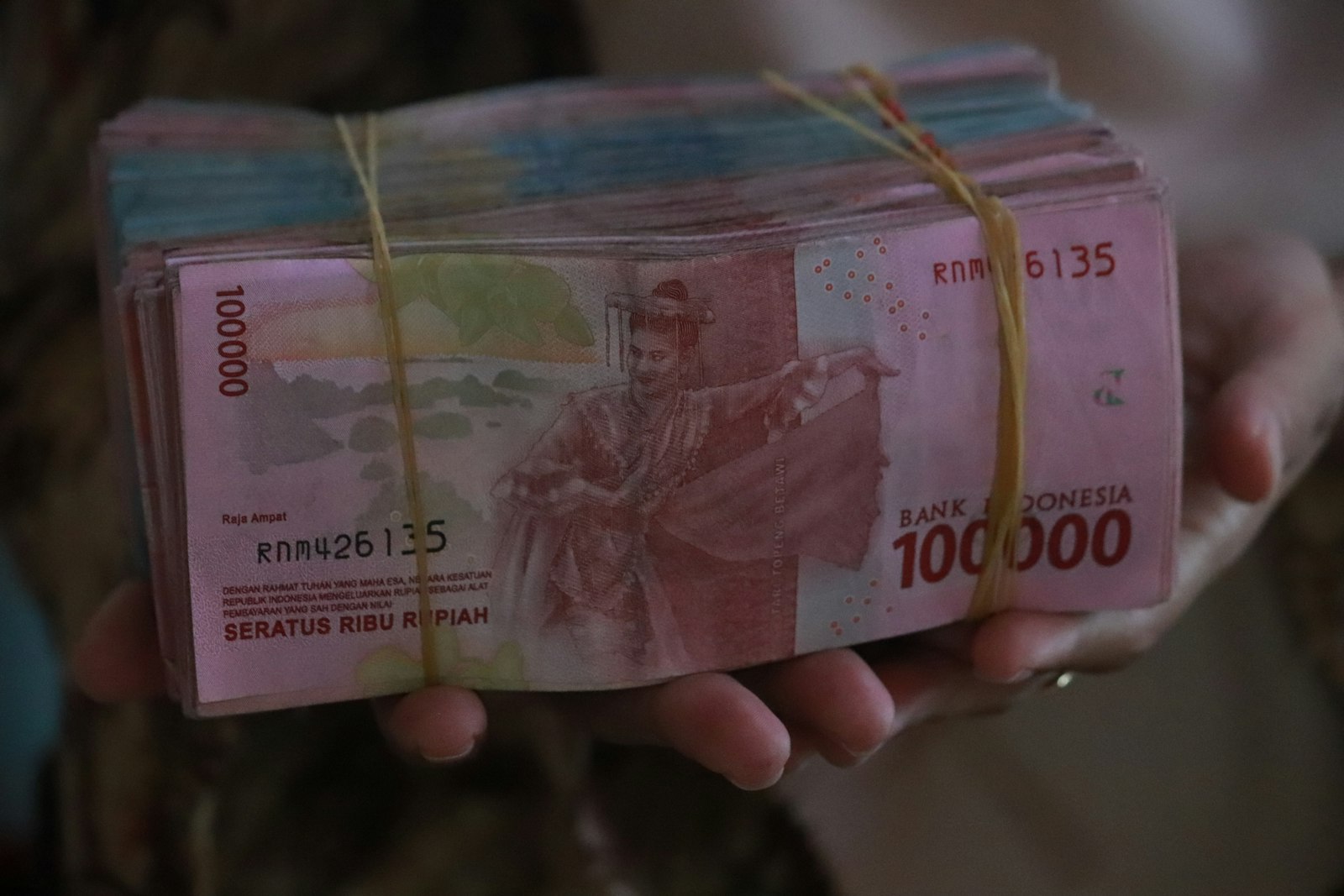 Hand holding Indonesian rupiah banknotes