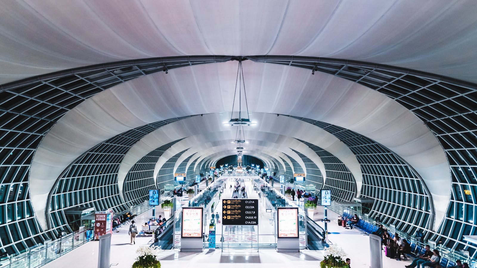 Travelers walking through Suvarnabhumi Airport terminal