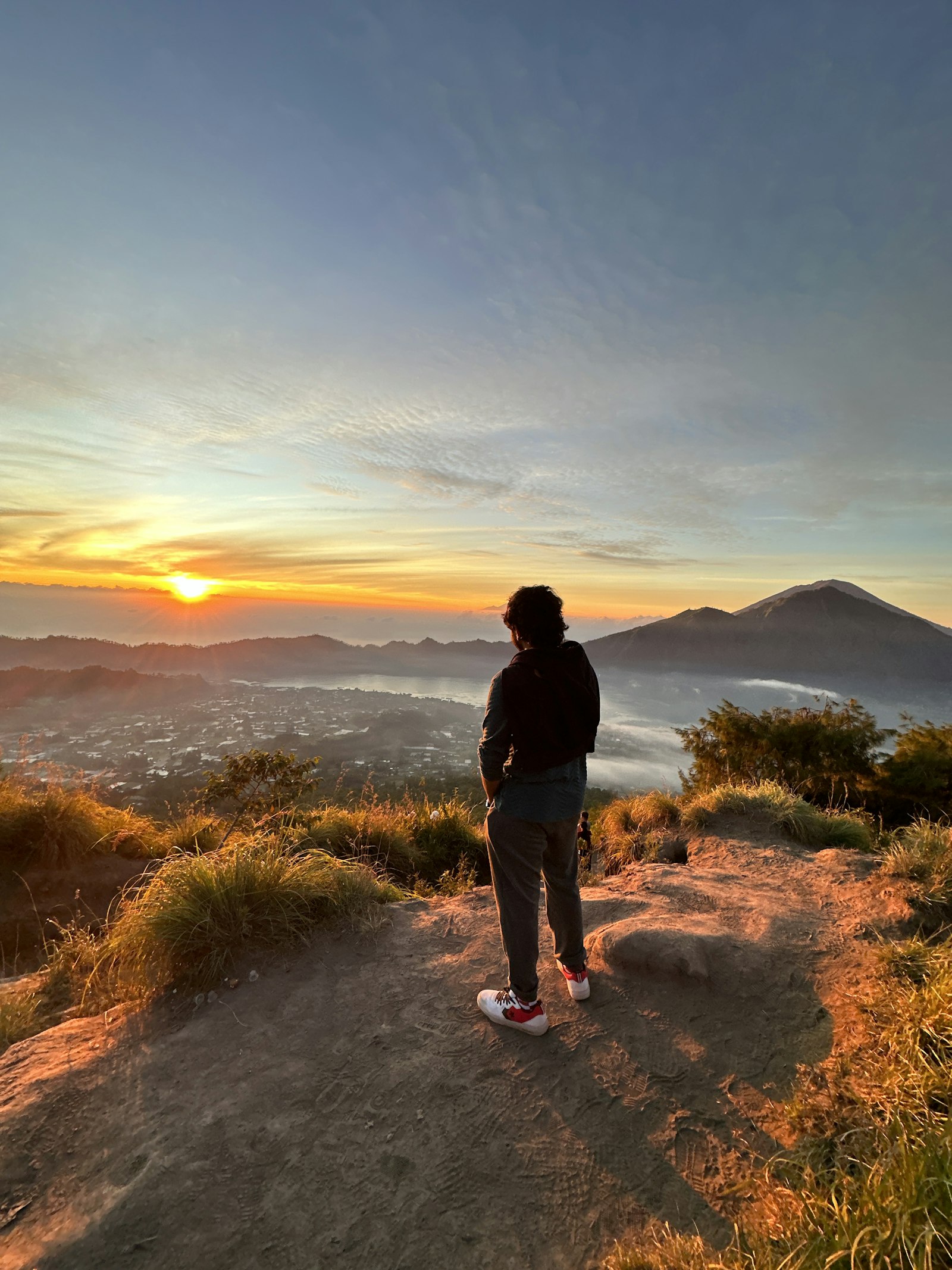 Person standing on a hilltop at sunset