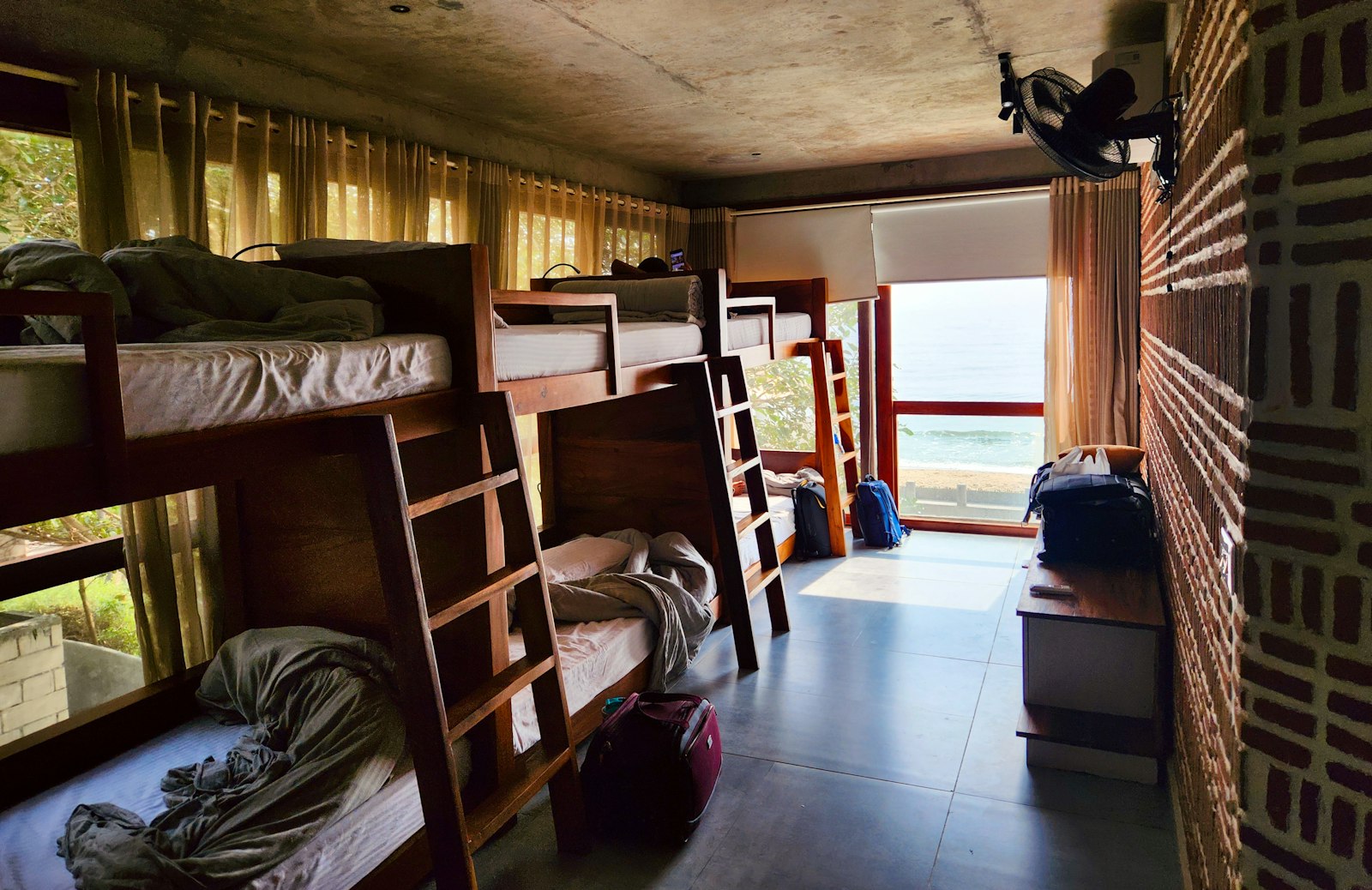 Dorm room interior with rows of bunk beds beside a window, Where to sleep