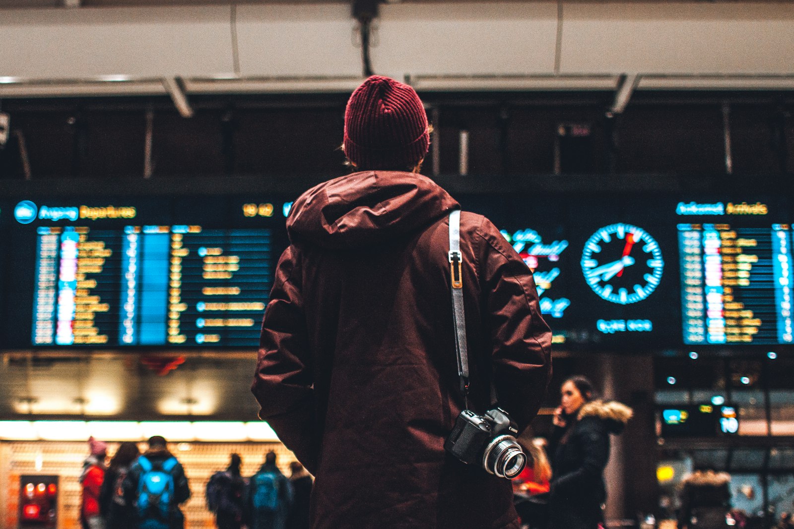 Traveler reading flight schedule board at airport